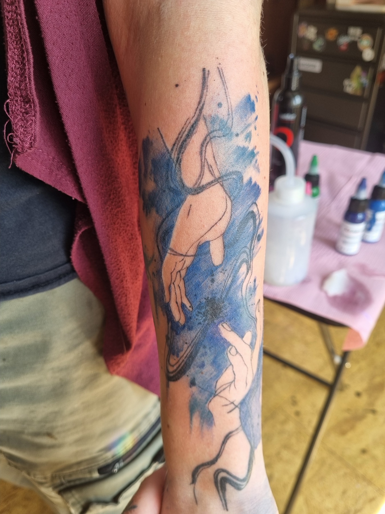 Blue painterly figure tattoo